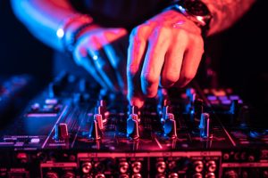 close-up-dj-hands-controlling-music-table-night-club